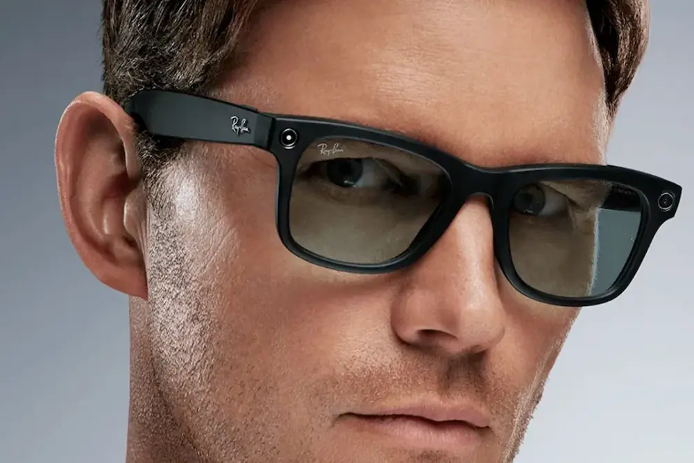 Person wearing Ray-Ban Meta Wayfarer smart glasses with the front-facing camera and capture light visible.